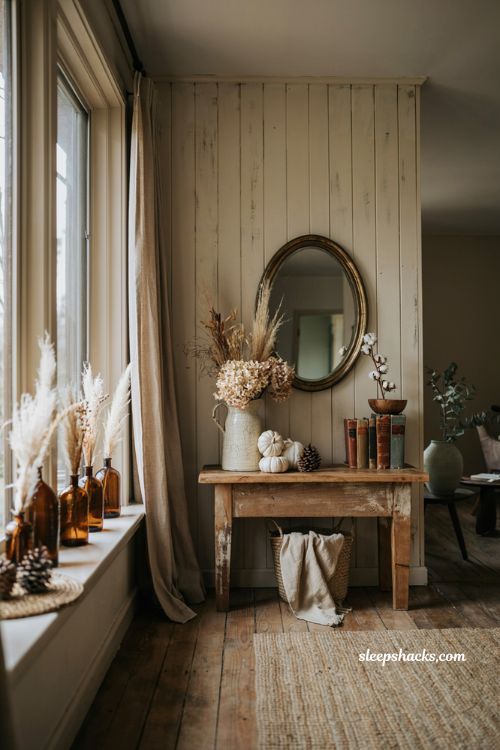 Farmhouse fall decor ideas with dried florals feathers and rustic neutral autumn styling