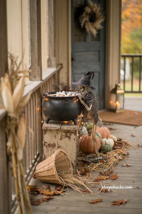 Farmhouse halloween porch ideas with a rustic cauldron vignette and skeleton witch
