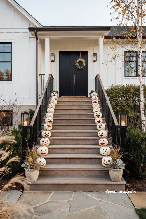 Farmhouse halloween porch ideas with white jack o lanterns lining the steps