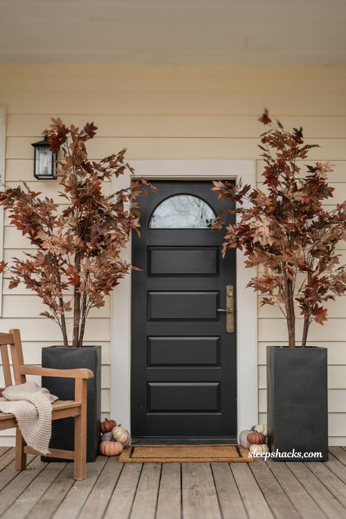 Faux maple trees in black planter boxes for a classic fall porch 
