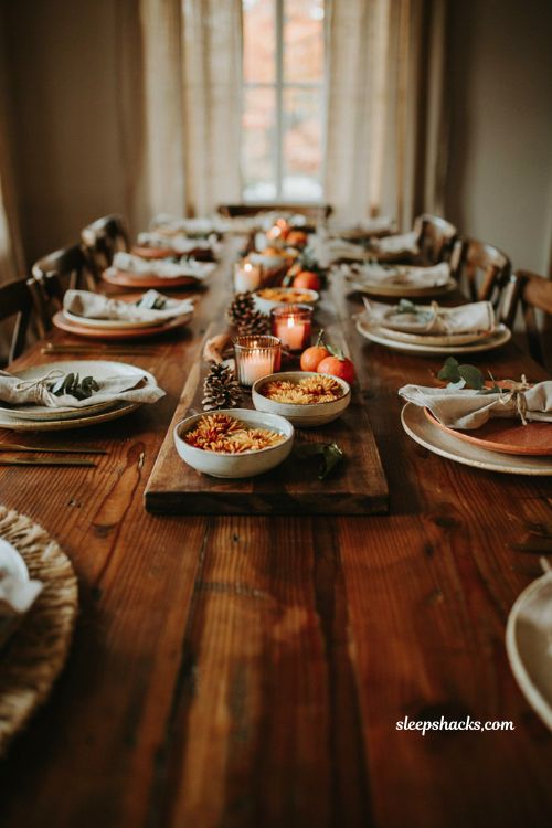 Floating mum blooms in shallow ceramic bowls on a wooden cheeseboard for a fall baby shower centerpiece