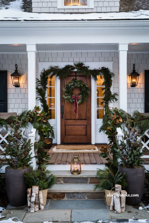 Fresh evergreen Christmas front porch with healthy wreaths garlands and winter greenery