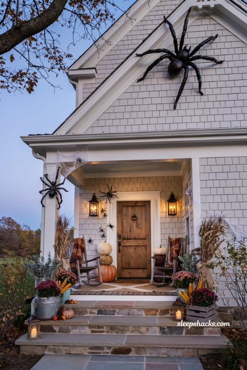 Front porch halloween ideas with giant spiders on farmhouse porch facade