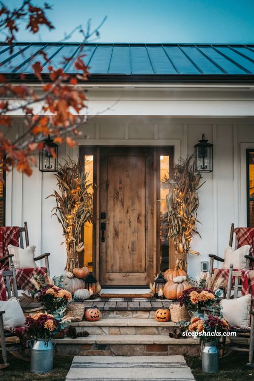 Front porch halloween ideas with lighted corn stalks pumpkins and farmhouse decor