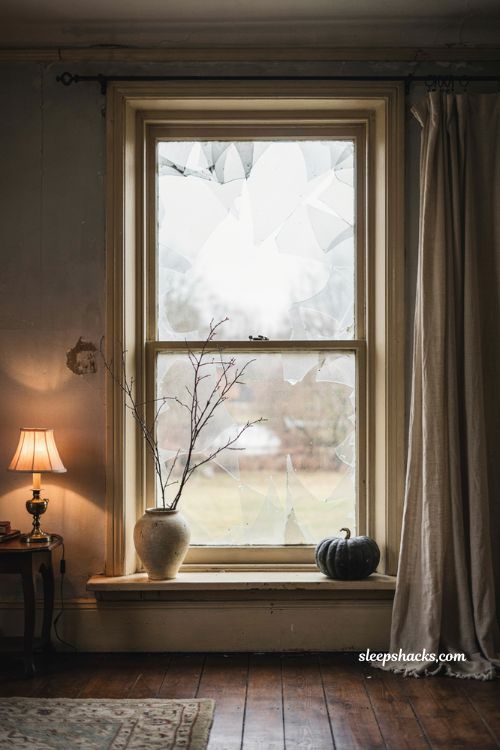 Frosted glass film Halloween window with eerie abandoned house cutouts and dim lamp glow