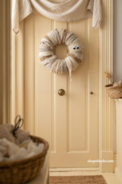 Gauze wrapped mummy wreath with googly eyes playful kid friendly Halloween door decor