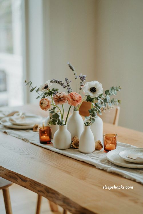 Gender neutral fall baby shower centerpiece idea with soft white ceramic bud vases anemones and eucalyptus