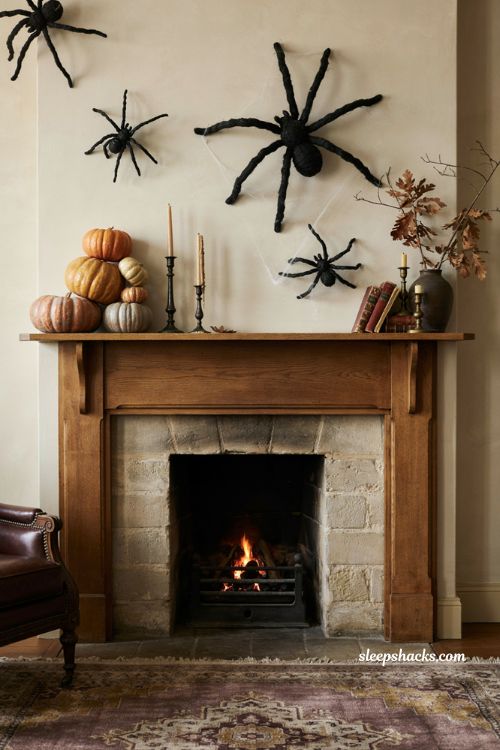 Giant spider Halloween fireplace decor with colorful pumpkins and dramatic mantel styling