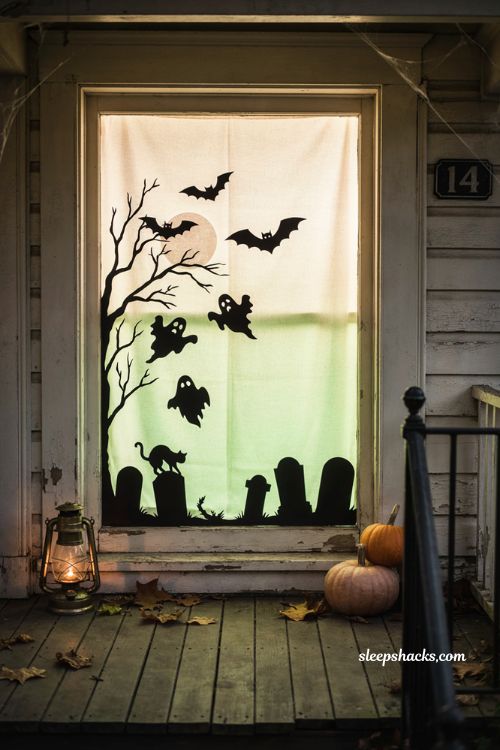 Green light Halloween window silhouette with glowing white backdrop 