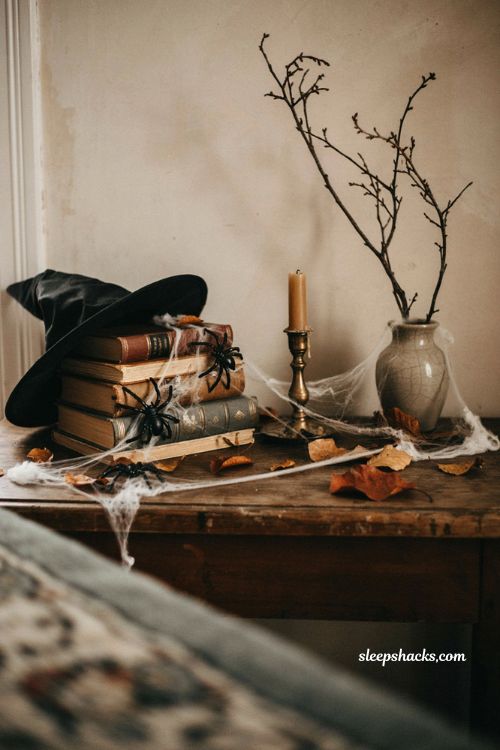 Halloween console table decor with vintage books cobwebs and spiders