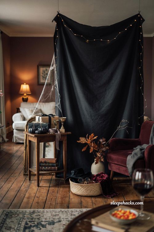 Halloween costume contest corner with black backdrop string lights and party decor
