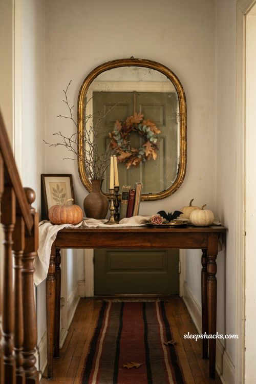 Halloween entryway decor with vintage pumpkins wreath and cozy console table