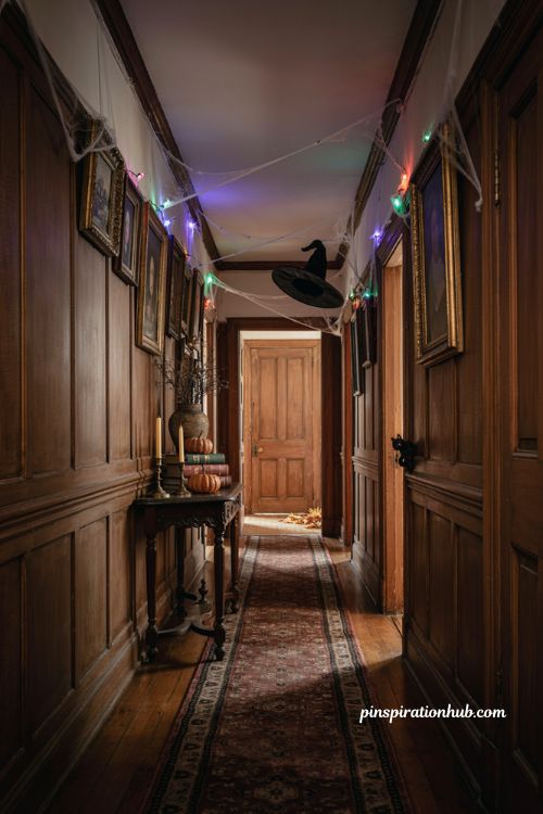 Halloween hallway ideas with layered cobwebs color changing lights wood paneling and witch hat