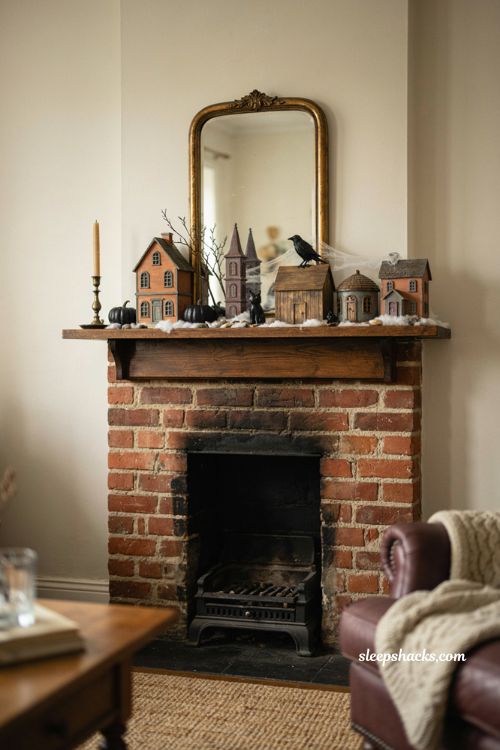 Halloween village mantel decor with spooky miniature houses and cozy fireplace styling