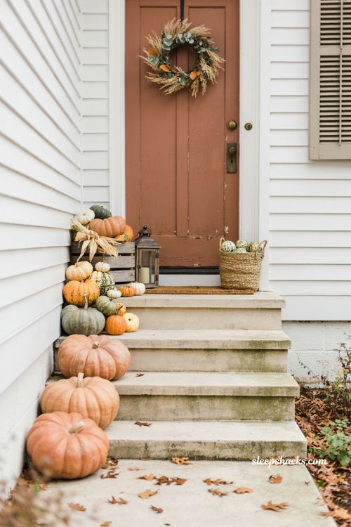 Heirloom pumpkin front steps Halloween decorations with orange, peach, cream, and green pumpkins 