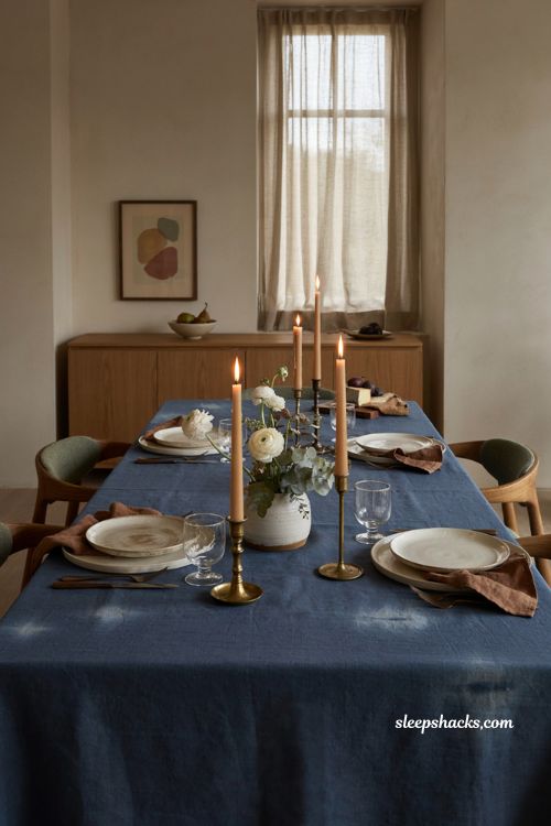 Indigo and brass Thanksgiving table with hand dyed linen cream pottery brown napkins and candlelit evening decor 