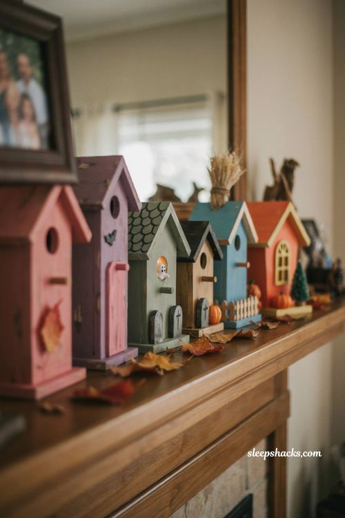 Kid painted Halloween village with mismatched handmade birdhouses and bats 