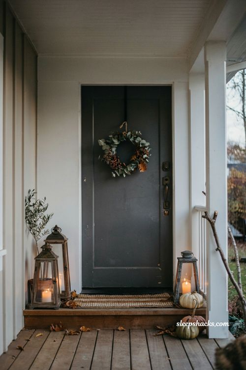 Lanterns and simple small front porch fall decor for a cozy entryway