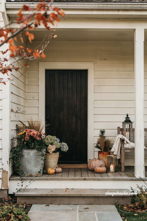 Layered small medium and large planters for a cozy fall front porch 