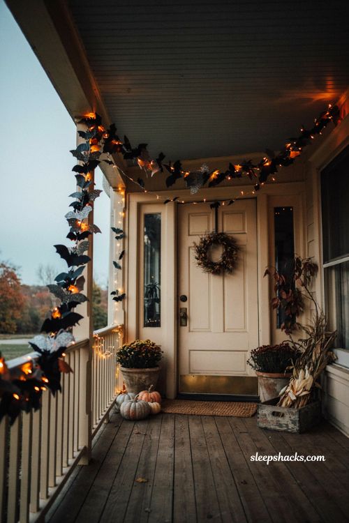 Lighted bat Halloween garland with warm orange lights on a cozy porch 