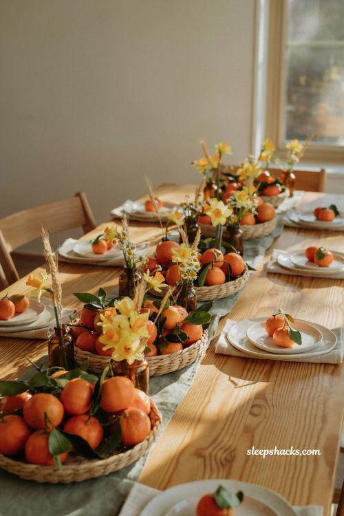 Little cutie fall baby shower centerpiece idea with clementines and daffodils in low woven baskets