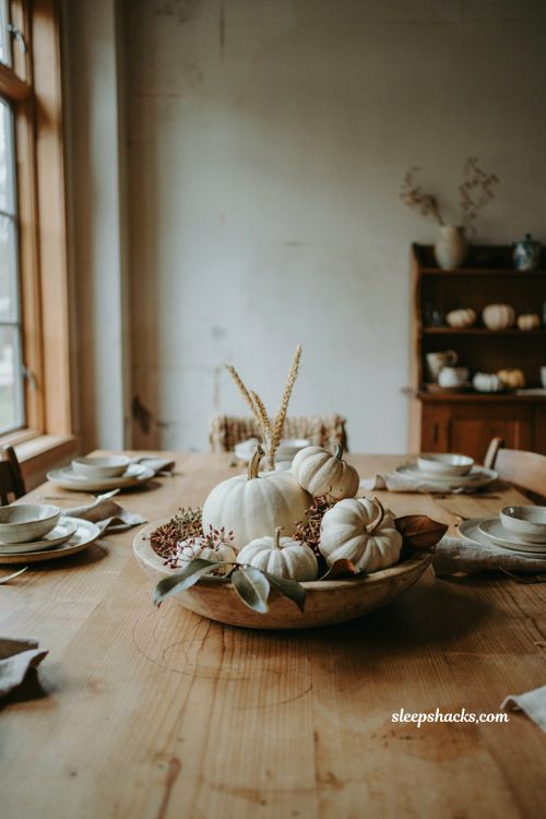 Low white pumpkin centerpiece with magnolia leaves berries and dried wheat