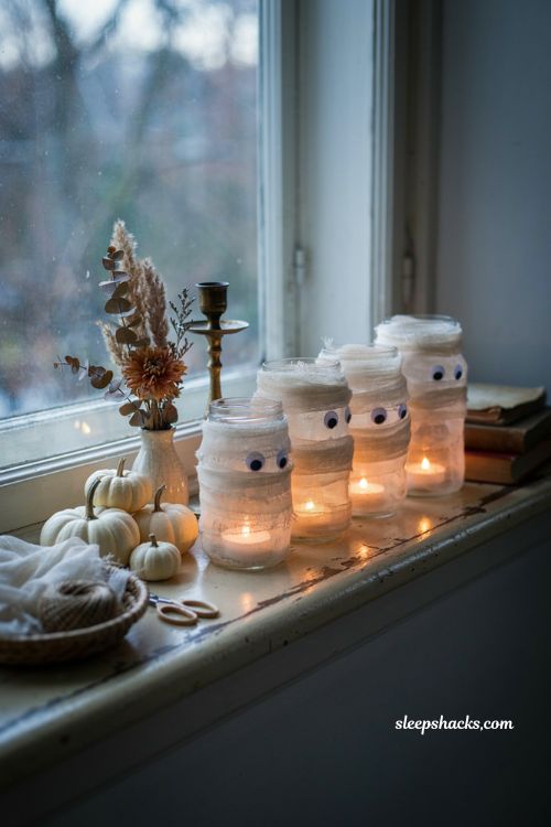 Mason jar mummy luminaries with gauze and glowing tea lights for DIY Halloween decor
