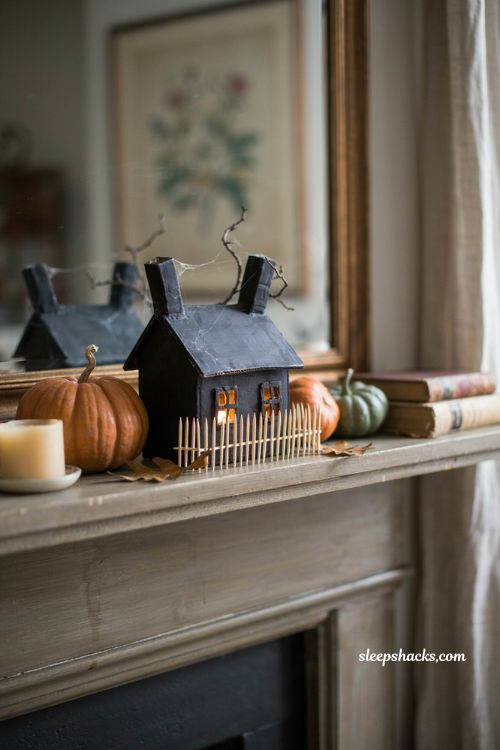 Miniature haunted house Halloween decor with glowing windows and pumpkins