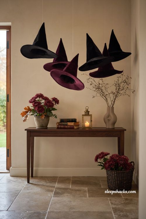 Modern Halloween entryway with floating witch hats and burgundy mums