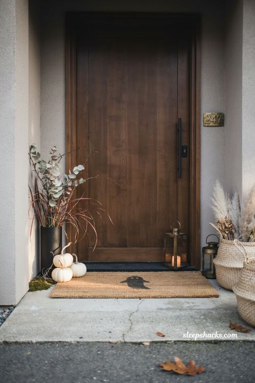 Modern black and white Halloween decor with white pumpkins black candlesticks and spiderwebs