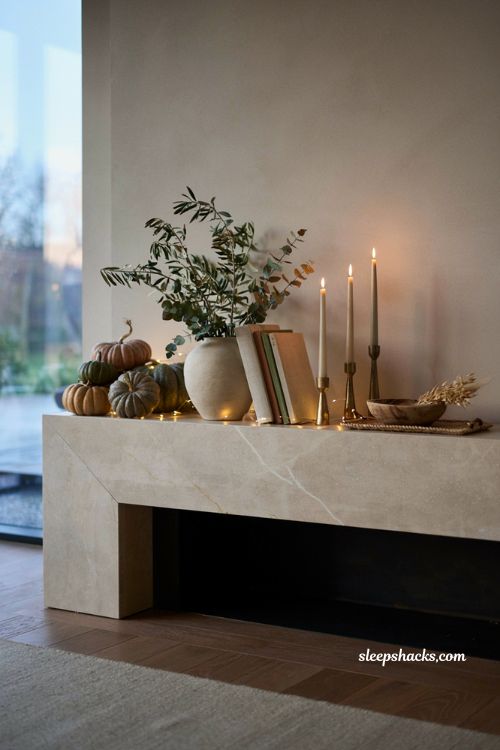 Modern fall decor ideas with fairy lights woven through a contemporary mantel display