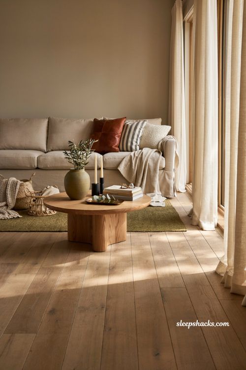 Modern fall decor ideas with leather accent pillows on a neutral linen sofa