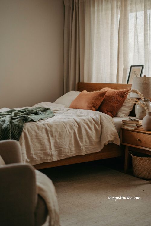Modern fall decor with layered forest green bedding and rust pillows 