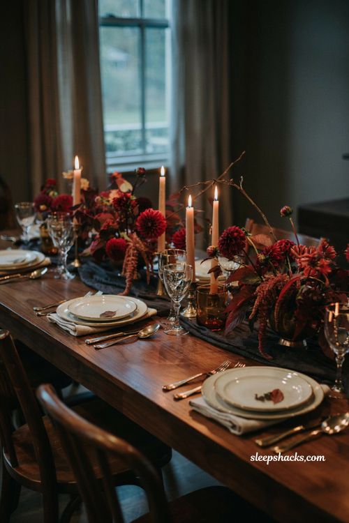 Modern fall decor with moody burgundy flowers and brass candlelight 
