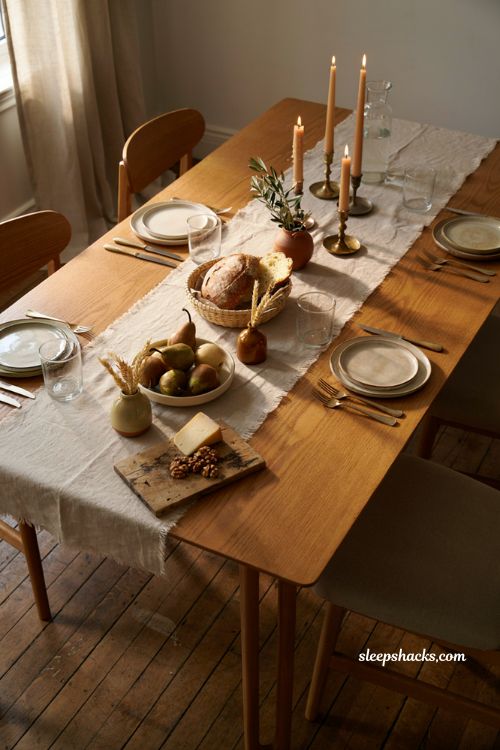 Modern fall decor with warm dining table linens candles and wicker basket 