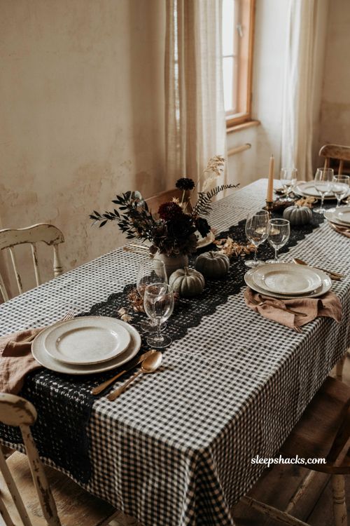 Moody Halloween dining table decor with black gingham tablecloth lace runner and autumn accents