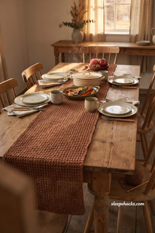 Moss stitch fall crochet table runner with cinnamon yarn woven texture and cozy farmhouse dining table