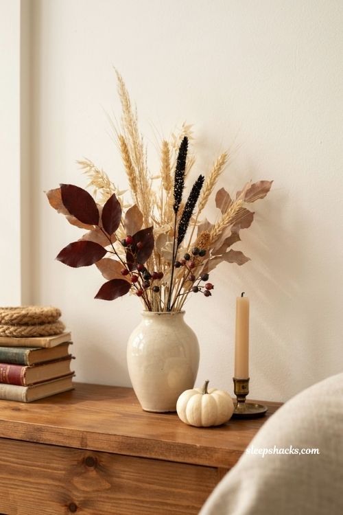 Neutral halloween decor with black floral stems deep plum leaves and dried botanicals