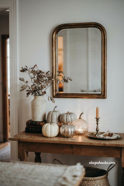 Neutral pumpkin Halloween decor with ceramic and glass pumpkins in an elegant entryway