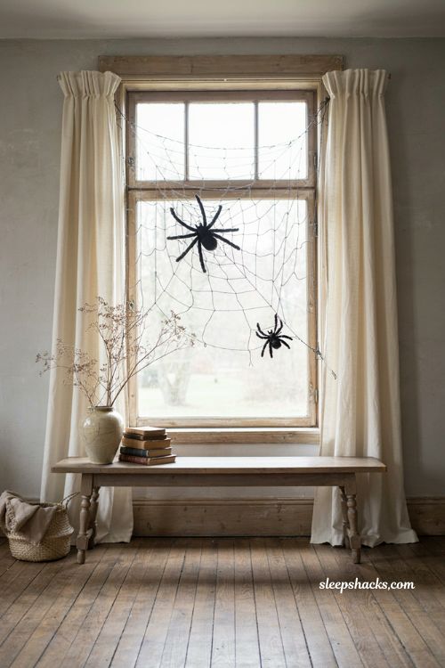 Oversized spiderweb over a window with black spiders for cheap Halloween decor 