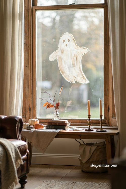 Painted ghost silhouettes on windows for cozy DIY Halloween decor
