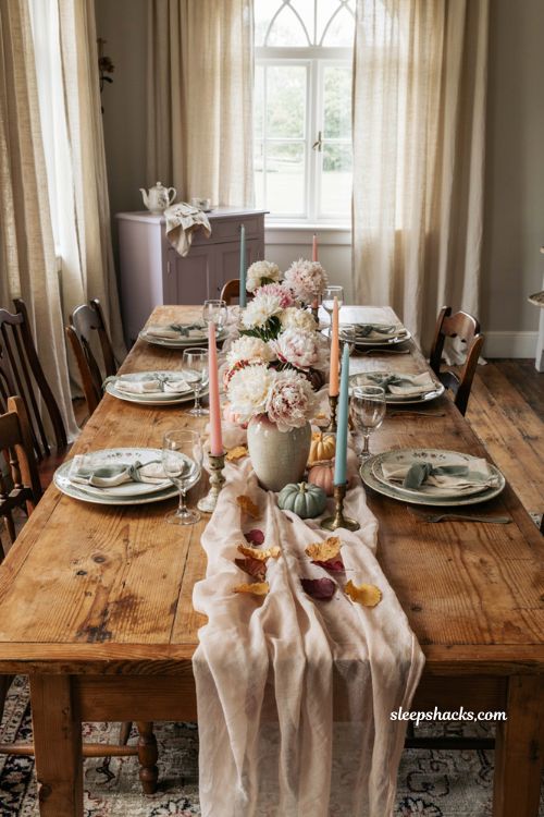 Pastel Halloween tablescape with pink blue peonies gauze and taper candles