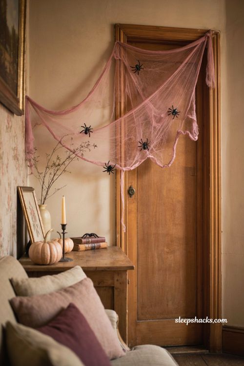 Pink and black spider web decor for a cozy spooky Halloween living room