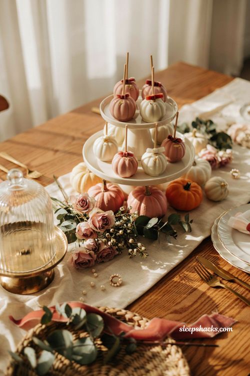 Pink pumpkin cake pop display with blush pumpkins for a fall baby shower