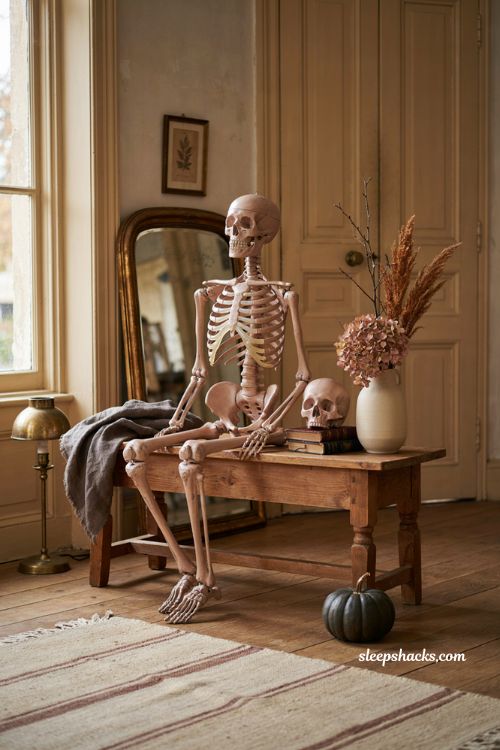 Pink skeleton accent on vintage books for unexpected Halloween decor