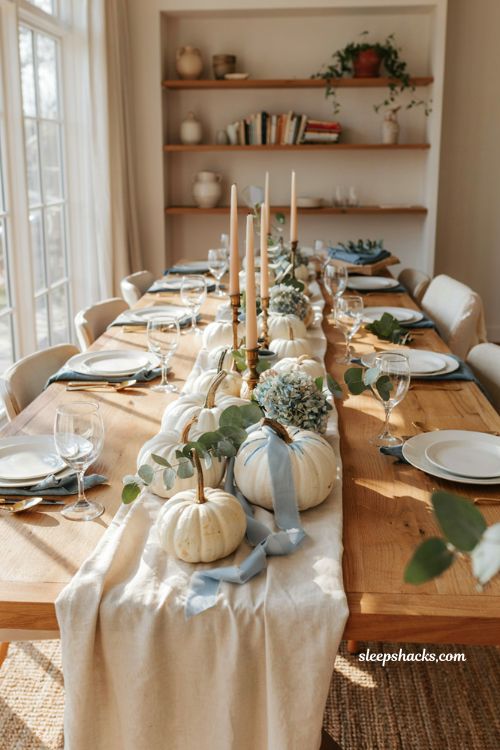 Pumpkin baby shower centerpiece with blue and white pumpkins and eucalyptus