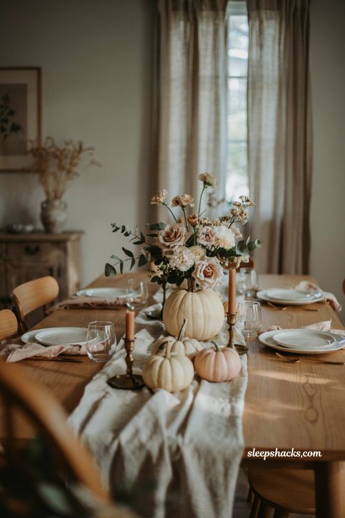 Pumpkin baby shower centerpiece with floral pumpkin topper roses and eucalyptus