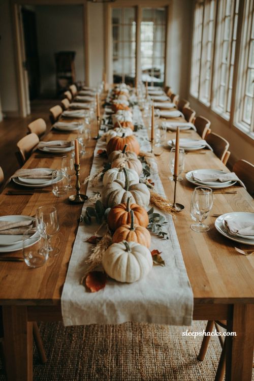 Pumpkin baby shower centerpiece with pumpkins layered by size and dried grasses