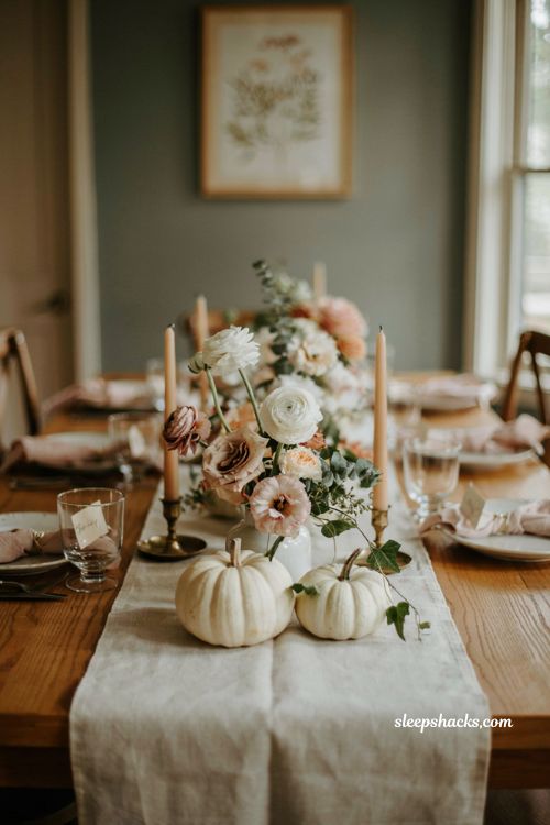 Pumpkin baby shower centerpiece with white pumpkins fresh florals and greenery