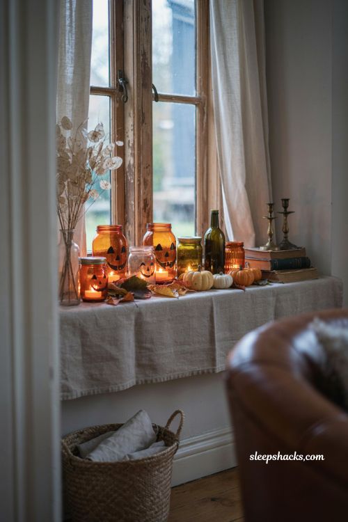 Pumpkin jar lanterns glowing on a windowsill for cozy Halloween decor